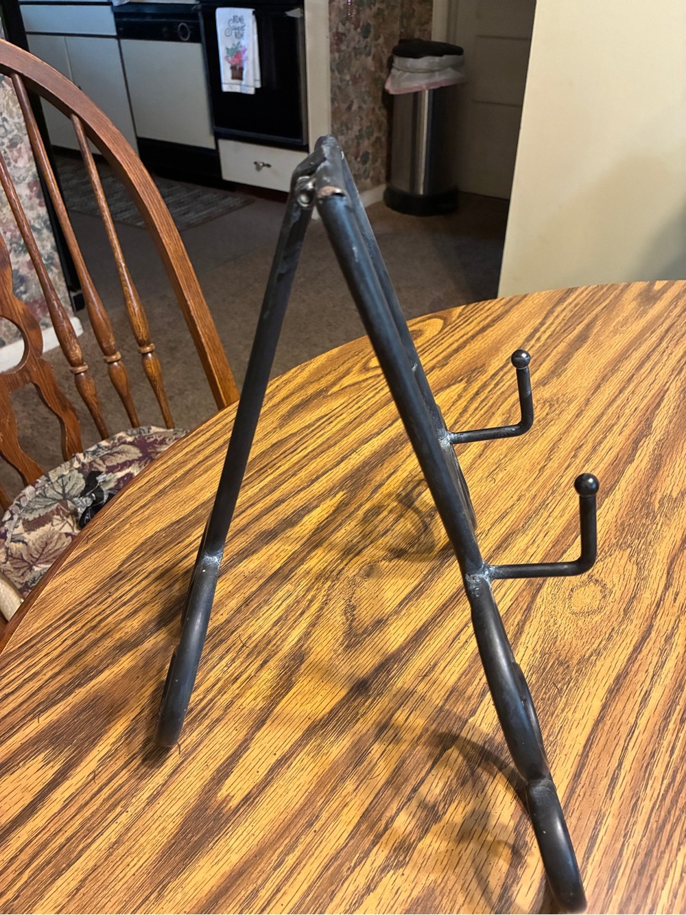 black metal table top easel features an intricate scroll work design - Picture 2 of 6